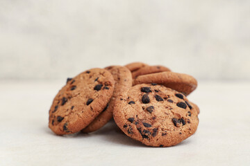 Many sweet cookies with chocolate chips on white background