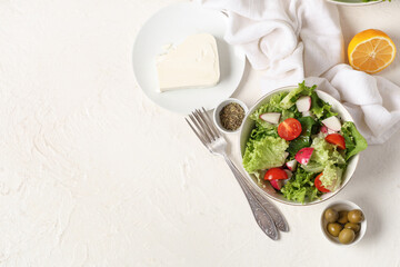 Composition with bowl of healthy salad, ingredients and forks on light background