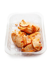 A tray of Cajun style chicken is on a white background. The chicken is cut into pieces. Small portion of poultry meat, ready to be eat or used for a sandwich.