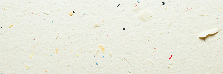 Unique textured cream paper with colored flecks and varied fiber distribution