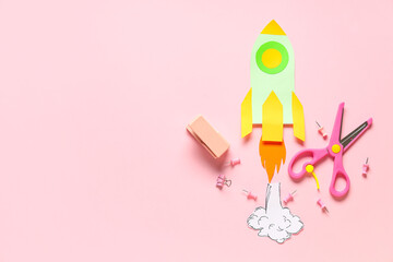 Paper rocket with smoke different school stationery on pink background