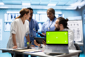 Licensed doctor and his staff review x ray scan results next to isolated copy space screen, examining hospital records before putting a diagnosis. Consulting analytics and radiography.