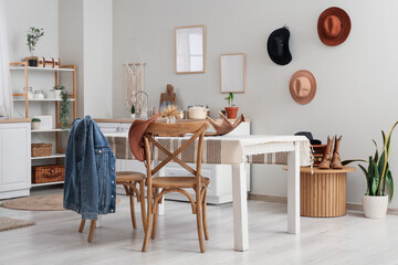 Interior of kitchen with dining table, cowboy hat and denim jacket on chairs