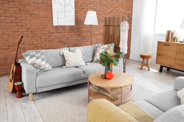 Sofa and coffee table with autumn decor in interior of living room