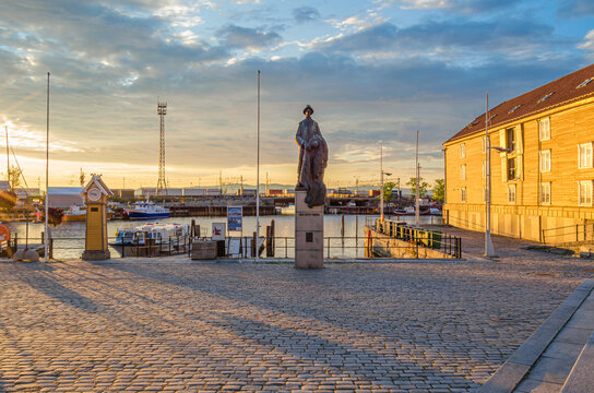 TRONDHEIM, NORWAY - JULY 22, 2014: View of Ravnkloa docks, a historic fish market area in Trondheim, Norway, and the "Last Viking" statue ("Den Siste Viking"), created by sculptor Nils Aas in 1990