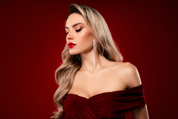 Blonde woman wearing glamorous off-shoulder red dress with stylish earrings
