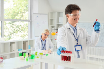 Male chemist with test tubes in laboratory