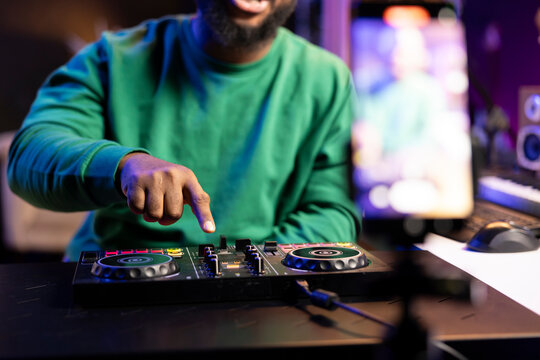 Sound designer expert filming a tutorial on how to learn the basic controls on a mixing console, teaching post production master class. Male artist producer explains audio recording techniques.