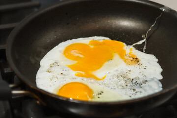 Frying Two Fried eggs with pepper