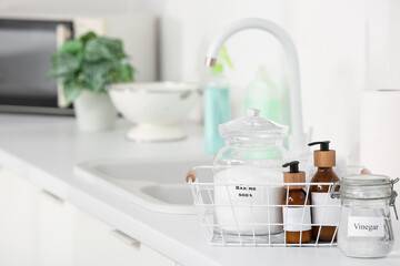 Basket with natural cleaning supplies on counter in kitchen, closeup