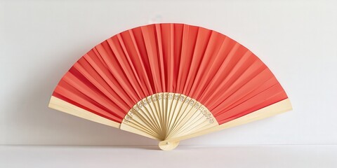 Elegantly designed red and beige folding fan, with intricate details on its top half, gracefully arcs to the right in a sophisticated display of artistry