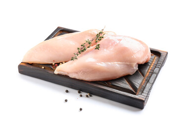 Wooden board with raw chicken breast, thyme and peppercorns on white background