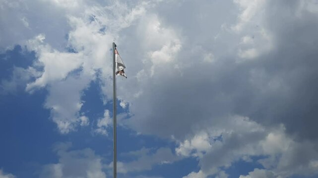 Latar belakang abstrak bendera indonesia berkibar ditengah langit biru yang cerah dan gumpalan awan putih