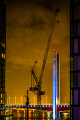 Construction site with cranes at night in Docklands, Melbourne, Australia, with Bolte Bridge and...