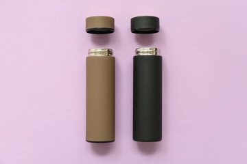 Different modern thermoses on lilac background