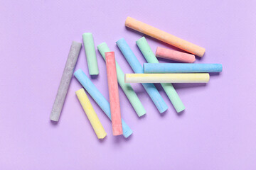 Colorful chalks on purple background