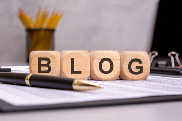 Fototapeta premium wooden cubes spelling BLOG on an office desk, symbolizing content creation, writing, and marketing