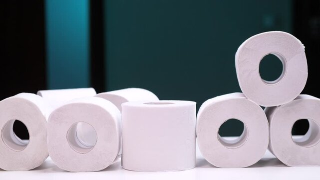 Hand taking toilet paper roll from a large pile