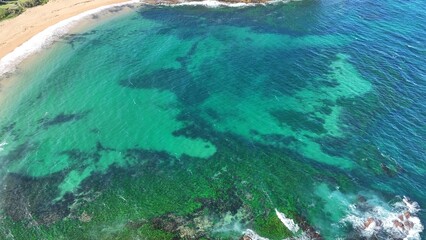 Obraz premium Drone shot aerial view of a beautiful turquoise water and reef near a beach in summer in Australia 