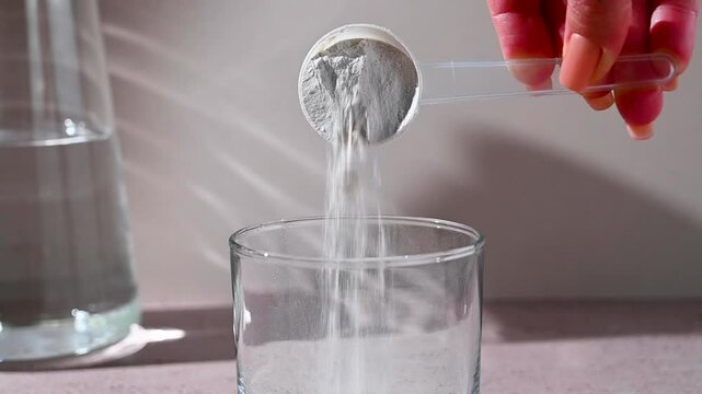 Amino acid food supplement, creatine powder in a measuring scoop and plastic jar