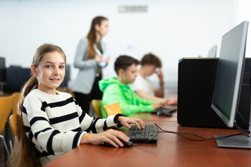 Fototapeta premium Schoolgirl using computer during computer sciene lesson in school.