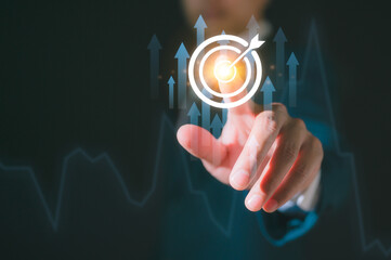 Goal Setting. A Businessman's Hand Points to the Glowing GOAL with a Dart Target Board work schedules, and the achievement of organizational objectives