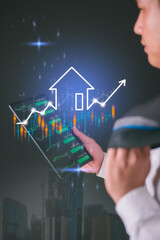 real estate investment concept man hand holding digital tablet and real estate growth graph...