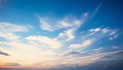 Blue sky is painted with feathery clouds, hints of warm colors on horizon.