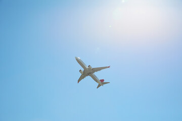 Modern white airplane flying in sky, low angle view