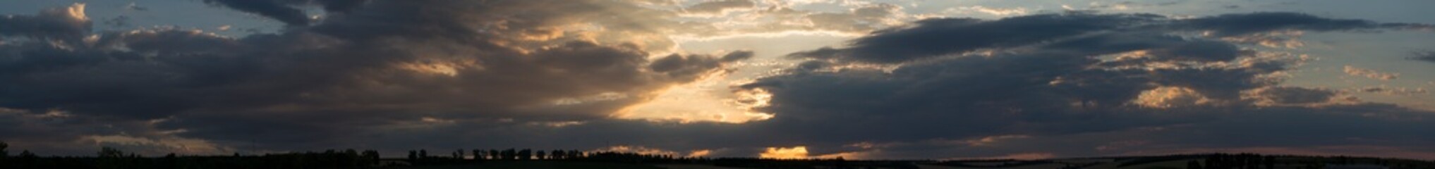 Landscape at sunset. Tragic gloomy sky. Panorama. Crimson twilight. Heavy, gloomy, dark clouds.