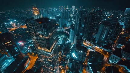 Naklejka premium Aerial night view of a bustling cityscape illuminated by vibrant lights.