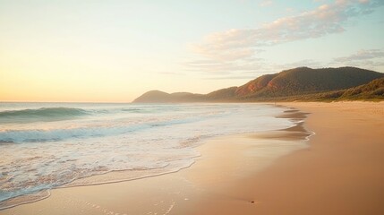 Fototapeta premium Serene beach at sunset with gentle waves lapping at the shore and distant mountains