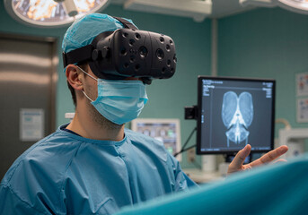 Surgeon Using Virtual Reality Technology in an Operating Room. A surgeon is using virtual reality (VR) technology during a surgical procedure. 