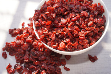Dried cranberries in white bowl on table.