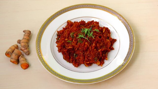 Raw turmeric stir-fry or kacha holud bhaji, served on a white plate on wooden table. It has anti-inflammatory properties, aids digestion, boosts immunity, good for skin, heart-healthy, prevent cancer