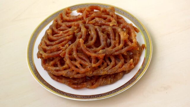 Delicious Shahi jilapi or jalebi on a white plate. Shahi jilapi, a famous traditional sweetmeat originating from Chowk Bazaar in Old Dhaka, Bangladesh, is very popular in the country.