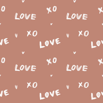 Seamless hand-drawn crayon love pattern with xo and hearts in warm tones on mocha mousse brown background