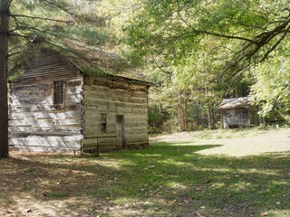 Old wood house in the Indiana countryside, with a small barn in the background (back view)
