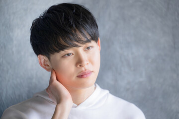 顎に手を当てる真剣な表情の男性　美容やビューティー、ヘアモデルのイメージ