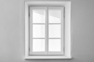 White framed window in a white wall allowing light inside