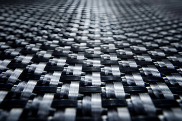 Fototapeta premium Close-up view of a woven black and silver textured surface, showcasing intricate patterns and depth