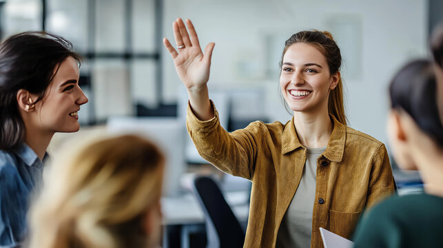 Young businesswoman raising hand and smiling during a meeting with her colleagues, actively participating and contributing to the discussion in a modern office environment - Powered by Adobe