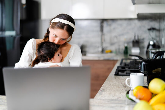 Mother multitasking, working from home while caring for baby - Powered by Adobe