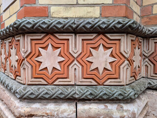 Detail of colorful brick and stone with 8 pointed octagram star designs on a building from the 1850s