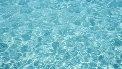Blue ripped seawater in a swimming pool. Crystal clear ocean lagoon bay turquoise blue azure water surface, closeup natural environment. Tropical Mediterranean beach water background