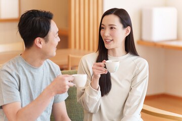朝起きてリビングでコーヒーを飲む夫婦