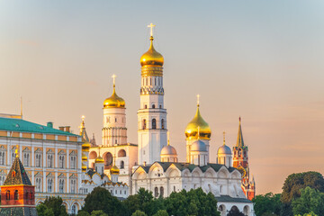 Ivan the Great Bell Tower, with Assumption Belfry on the right in Moscow Kremlin. Blue sky background with sunbeams