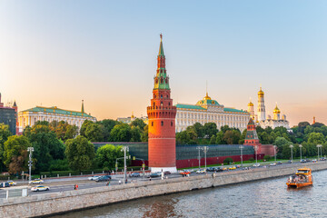 Obraz premium View of Kremlin with Vodovzvodnaya tower, Grand Kremlin Palace from repaired Bolshoy Kamenny Bridge in Moscow city on sunny summer day. Cruise ship sails on the Moscow river