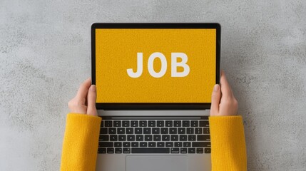 Person searching for a job online using laptop computer. Hands hold the device showing the word JOB on screen.