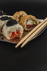 Delicious sushi rolls served on a silver platter with chopsticks